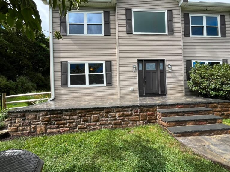 Backyard stone patio with masonry steps and retaining wall