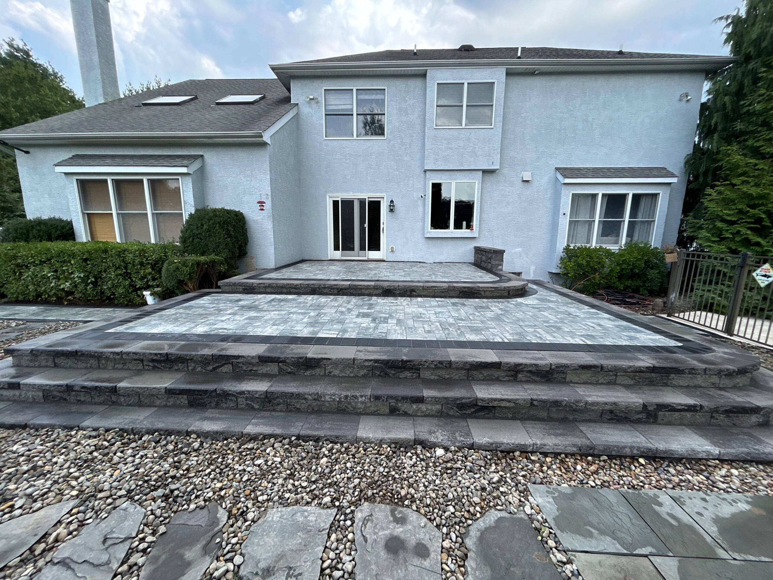 Backyard paver patio with wide masonry steps in Wayne NJ