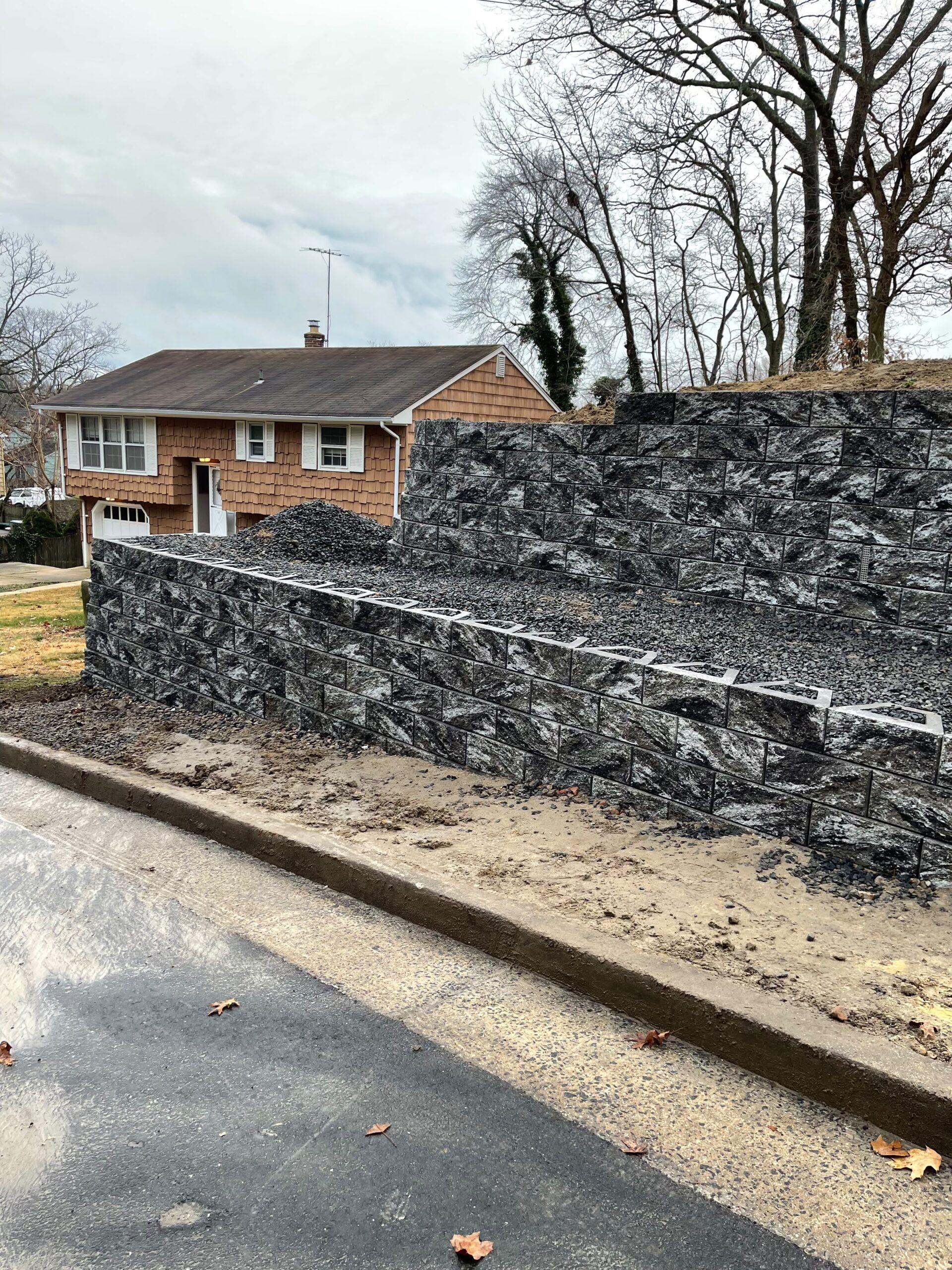 Large stone retaining wall along residential street