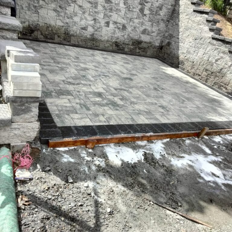 Paver patio with dark border and retaining wall in Morris Plains NJ