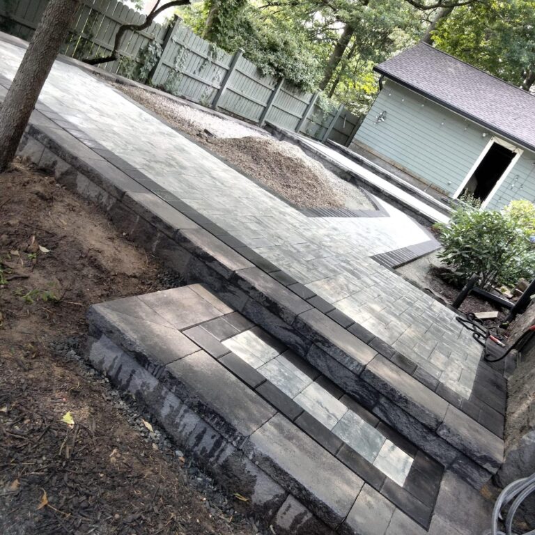 Raised paver patio construction with stone wall
