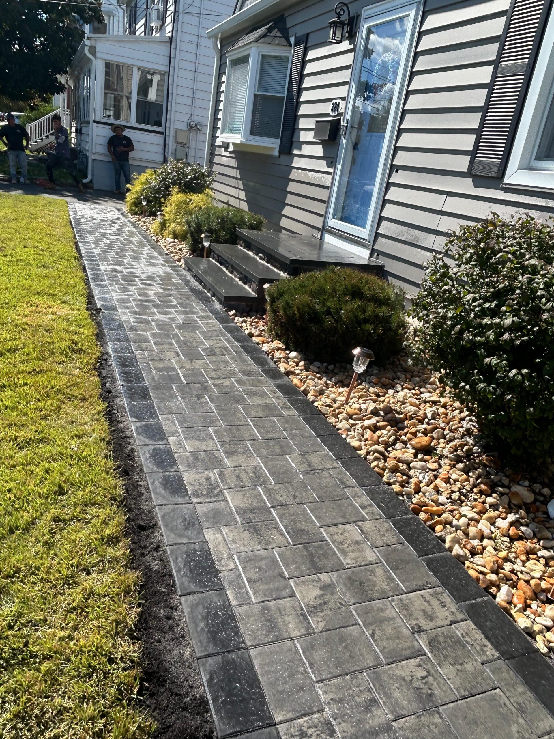 Side yard paver walkway with stone landscaping