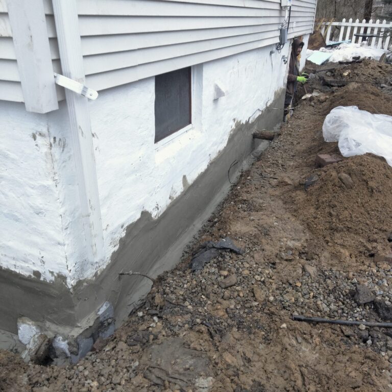 Exposed foundation wall being prepared for waterproofing