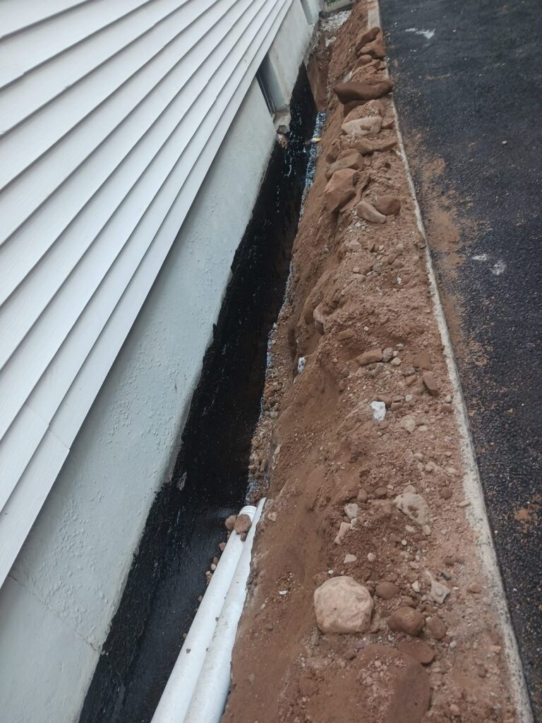 Exterior waterproofing membrane applied to a foundation wall