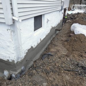 Exposed foundation wall being prepared for waterproofing