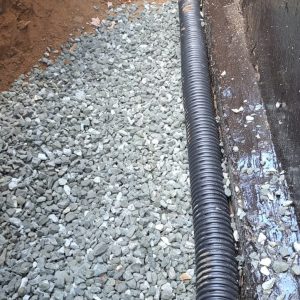 Perforated footing drain installed beside a foundation