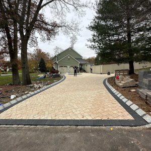 Custom paver driveway with dark border and stone edging in Montville NJ