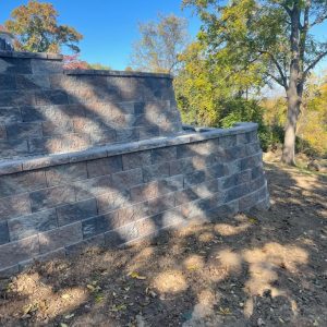Finished masonry retaining wall with stone finish