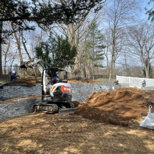 Retaining wall construction with excavator