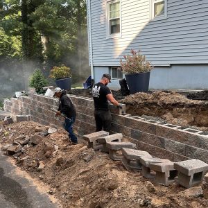 Retaining wall installation by masonry crew